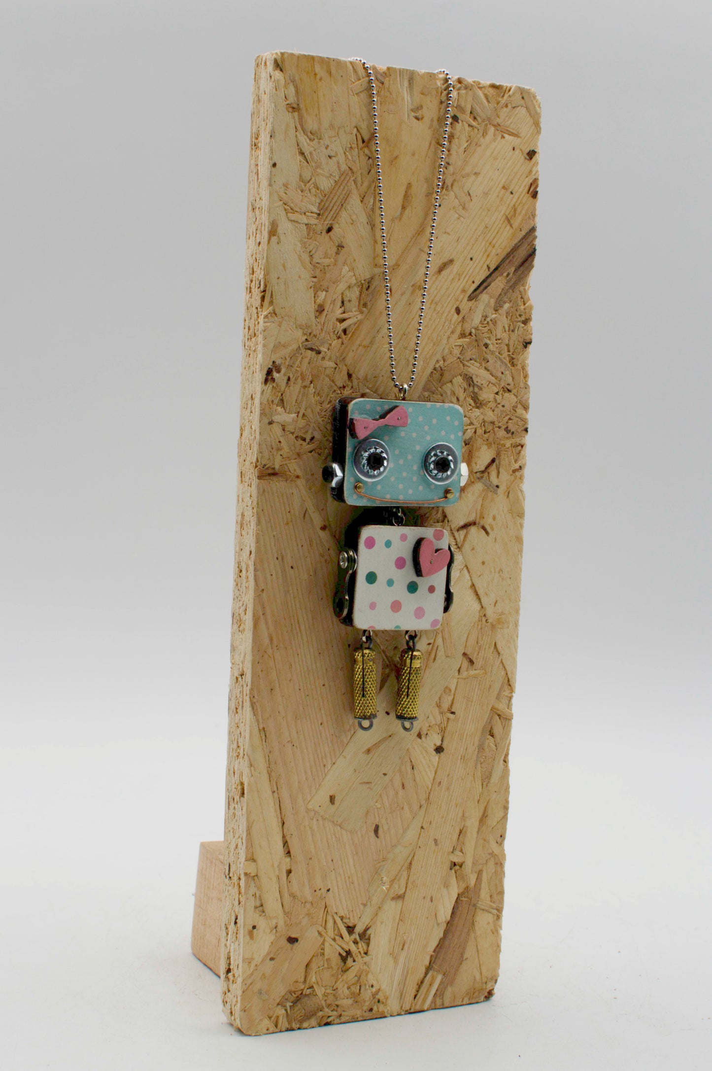 Ciondolo robot in legno tagliato a laser blu e bianco a pois con fiocco rosa su collana pendente fatta a mano