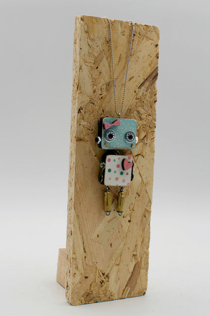 Ciondolo robot in legno tagliato a laser blu e bianco a pois con fiocco rosa su collana pendente fatta a mano
