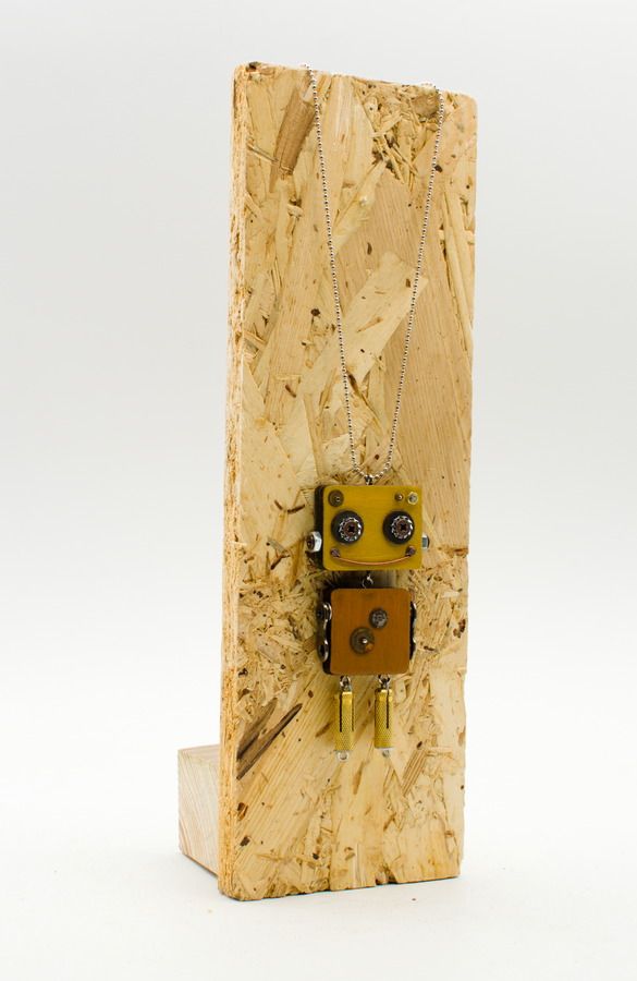 Ciondolo robot in legno tagliato a laser giallo e marrone con occhi metallici realizzato con componenti elettronici riciclati