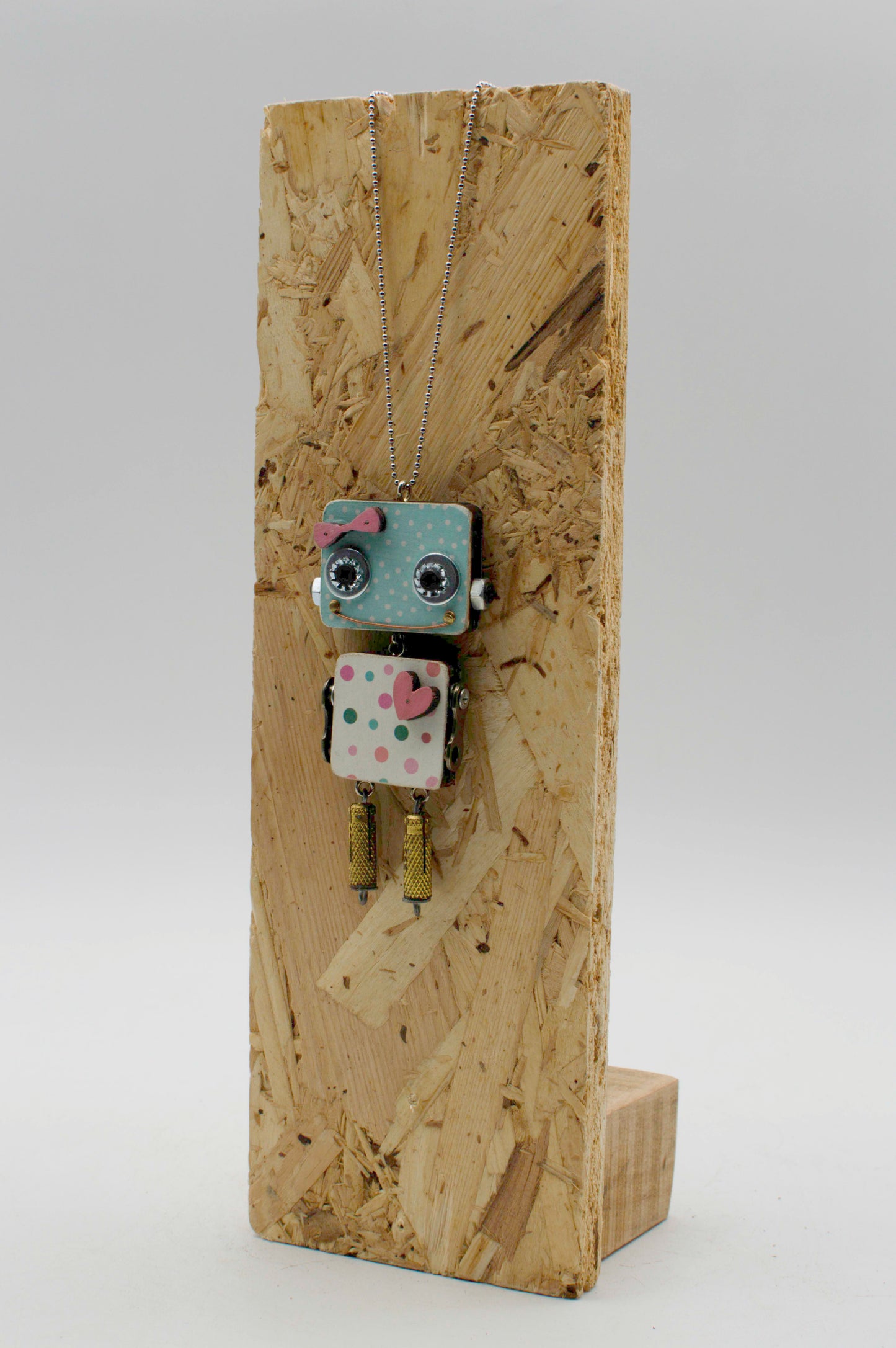 Ciondolo robot in legno tagliato a laser blu e bianco a pois con occhi neri cuore rosa e frange dorate fatto a mano