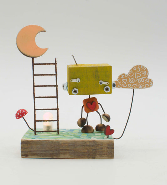 Diorama scultura luminosa stile robot fatto a mano con testa gialla, torso a cuore rosso e base rustica con scala e luna
