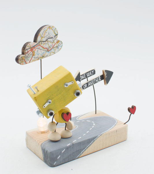 Diorama scultura luminosa robot in legno giallo con nuvola a mappa e segnaletica su base stradale dipinta