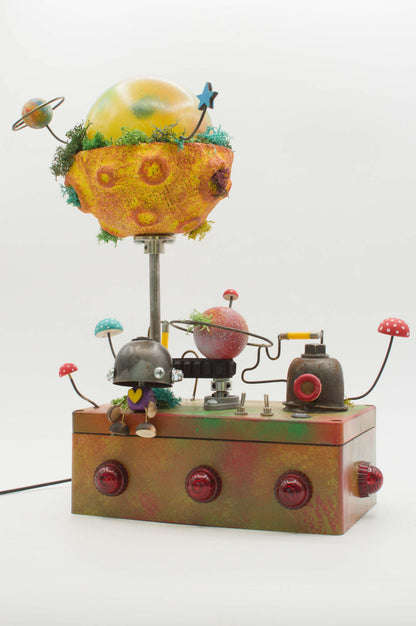 Lampada robot artigianale in metallo riciclato con globo pianeta giallo arancione e base metallica con pulsanti rossi
