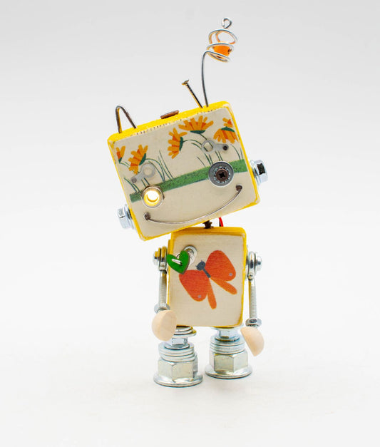 Lampada robot giocattolo gialla in ceramica e metallo con testa a motivo floreale e torso a farfalla modello illustrato