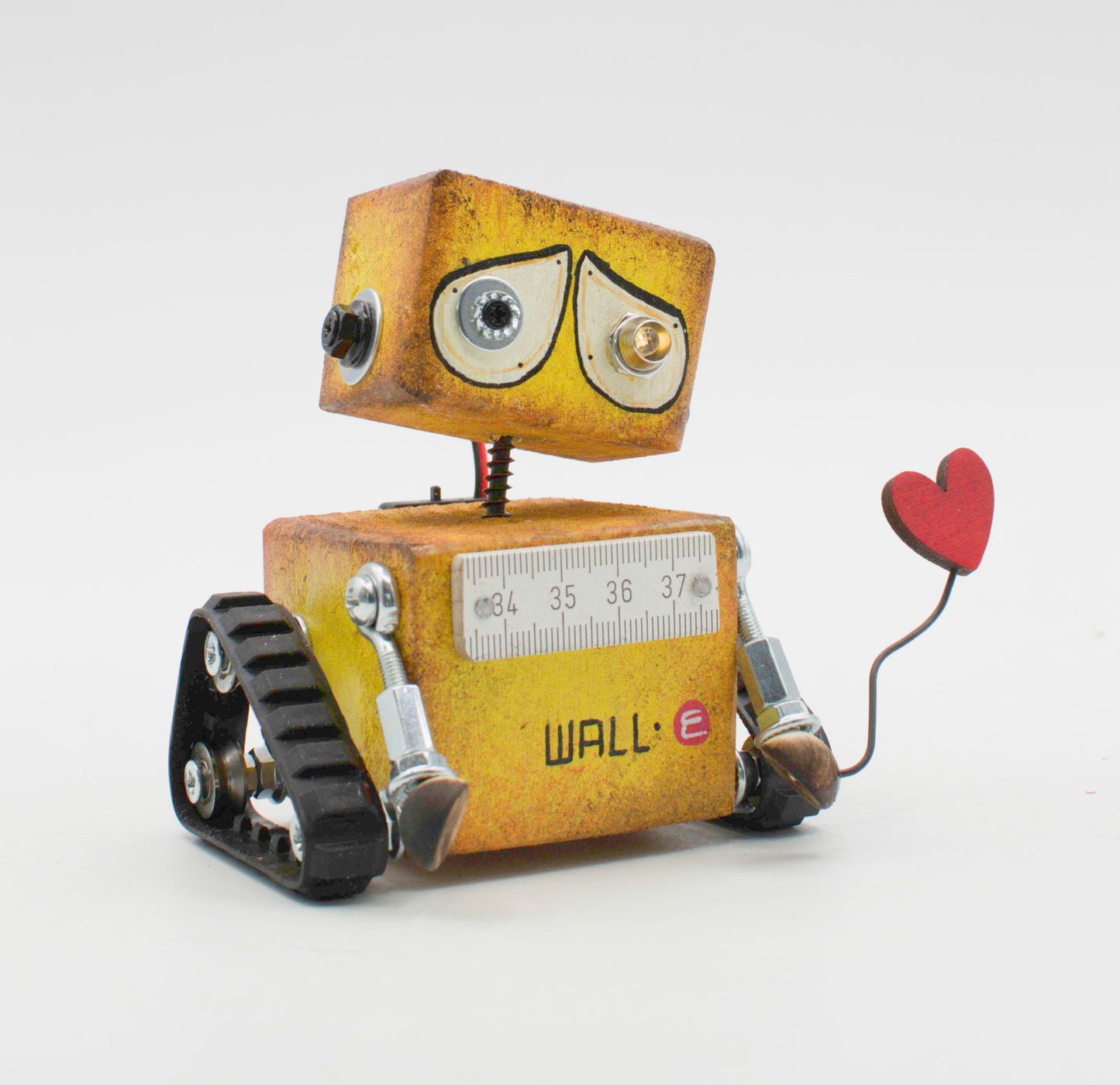Rustico cortesia robot in metallo giallo con righello sul petto e cuore rosso, lampada a batteria in stile wall-e fatta a mano