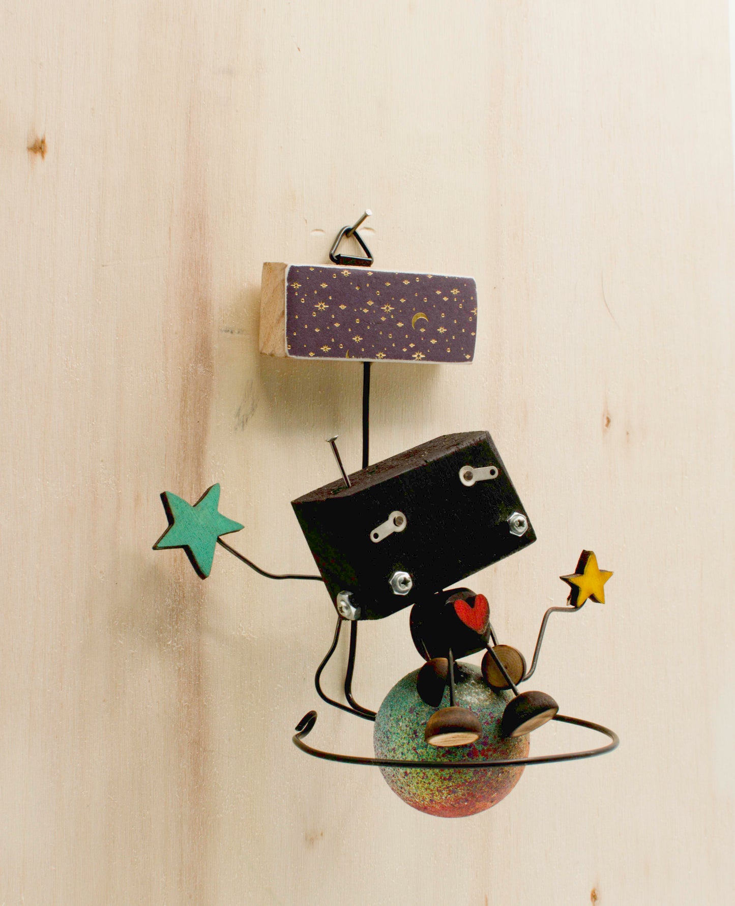 Minibot da appendere scultura robot nero in metallo fatto a mano con braccia a forma di stelle e base a globo maculato