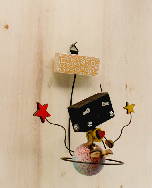 Minibot da appendere scultura robot fatta a mano con testa nera rettangolare braccia stella rosse e gialle gambe metalliche e base globo macchiato