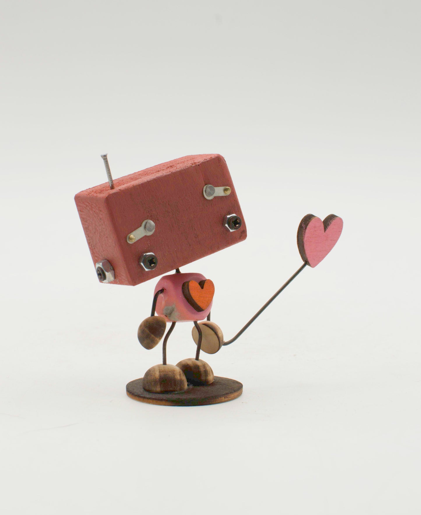 Minibot scultura robot fatto a mano in metallo marrone con torso a forma di cuore e cuore rosa su bastone