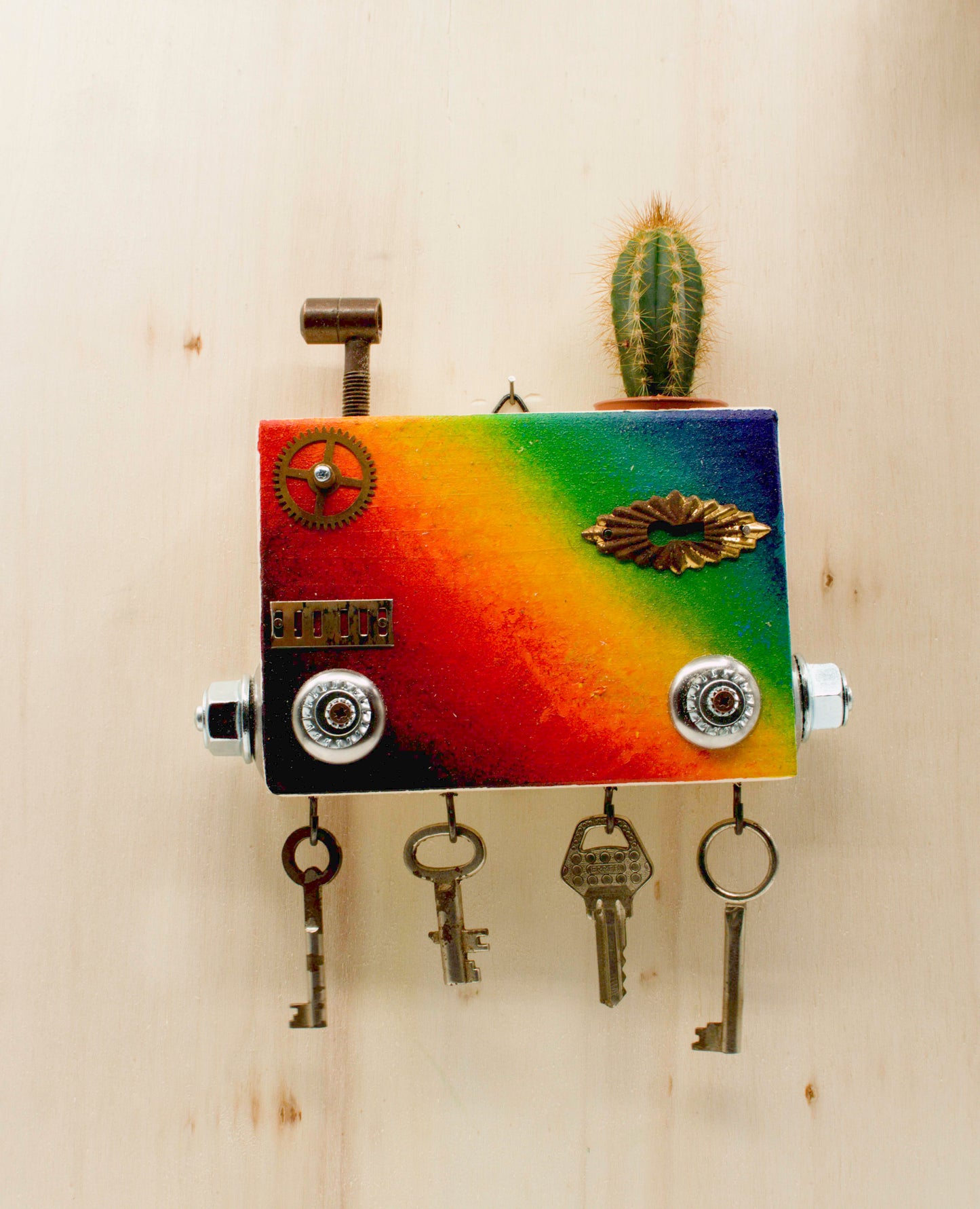 Portachiavi da parete scultura robot fatto a mano in metallo dipinto arcobaleno con chiavi vintage e piccolo cactus sopra