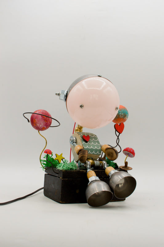 Lampada robot artigianale con cupola rosa e corpo in metallo riciclato decorato con cuori rossi e base nera pezzo unico