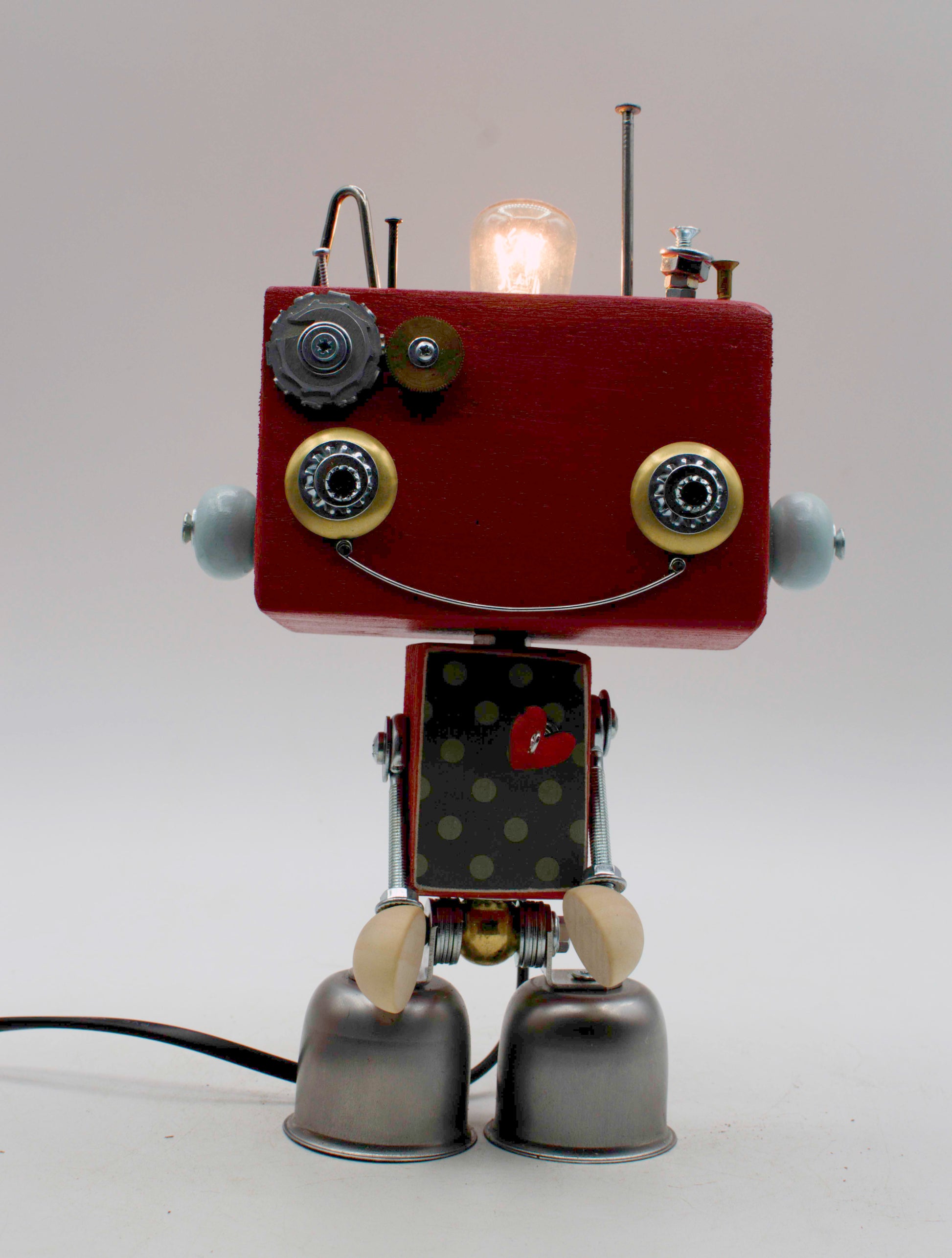 Lampada da tavolo robot beat steampunk con testa rossa, occhi cerchiati di ottone e parti metalliche riciclate