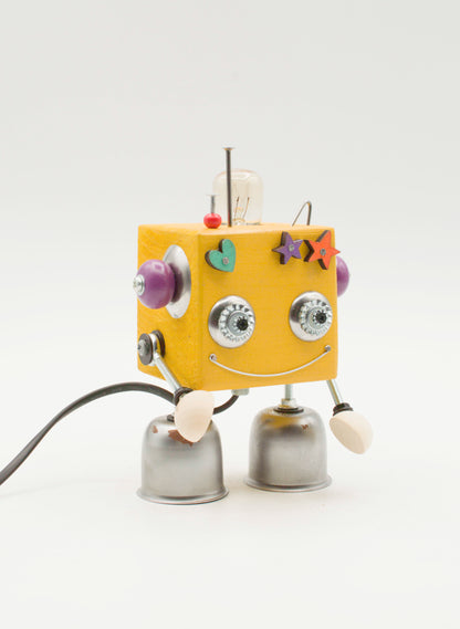 Lampada da tavolo cubot robot gialla a forma di cubo con manopole viola occhi metallici e gambe a campana fatta a mano