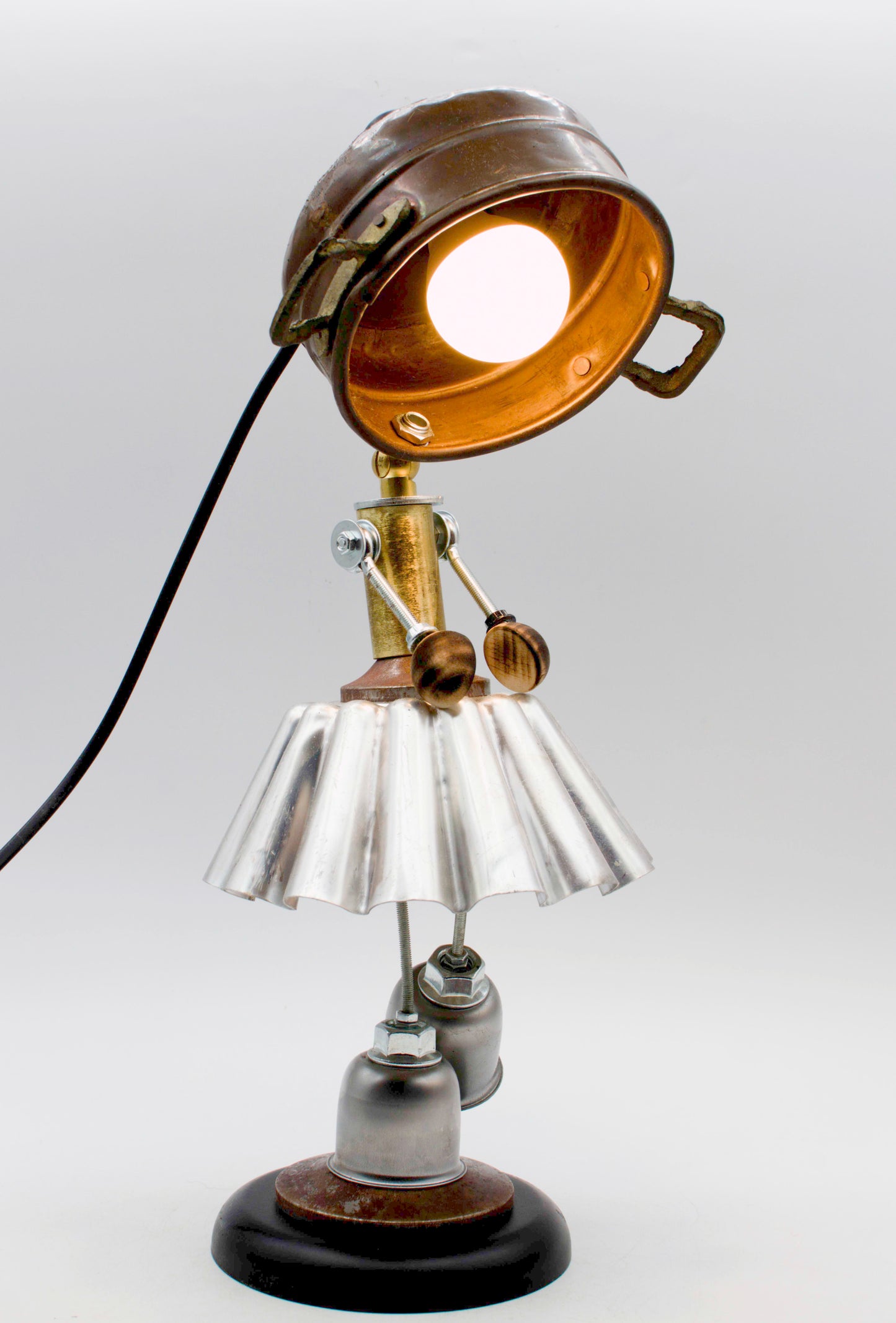 Lampada da tavolo ballerina robot industrial con testa in ottone e nero, gonna plissettata argento in alluminio e gambe grigio scuro