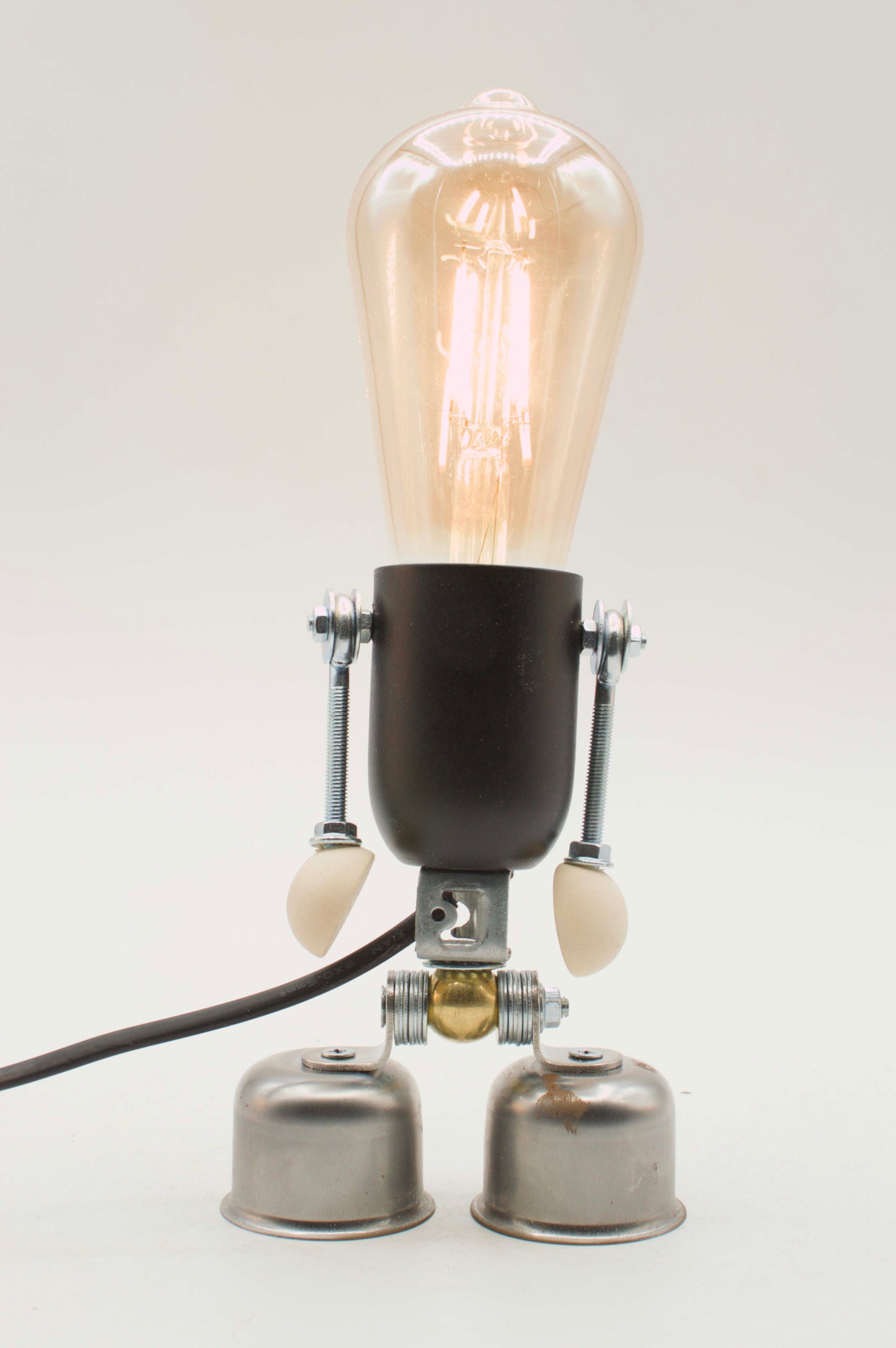Lampada da tavolo robot stile edi nera e ottone con bulbo ambrato a filamento e mani beige fatta a mano