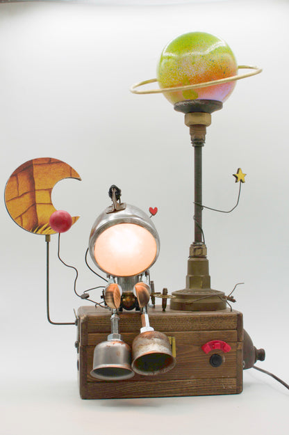 Robot lampada da tavolo stile Galattico fatta a mano con testa luminosa circolare e pianeta verde con anelli su base legno scuro