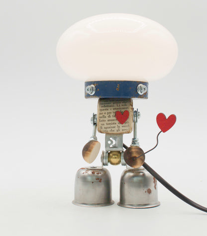 Graziosa lampada creata come robot lampada da tavolo stile fanale con cupola bianca e corpo in tappi riutilizzati