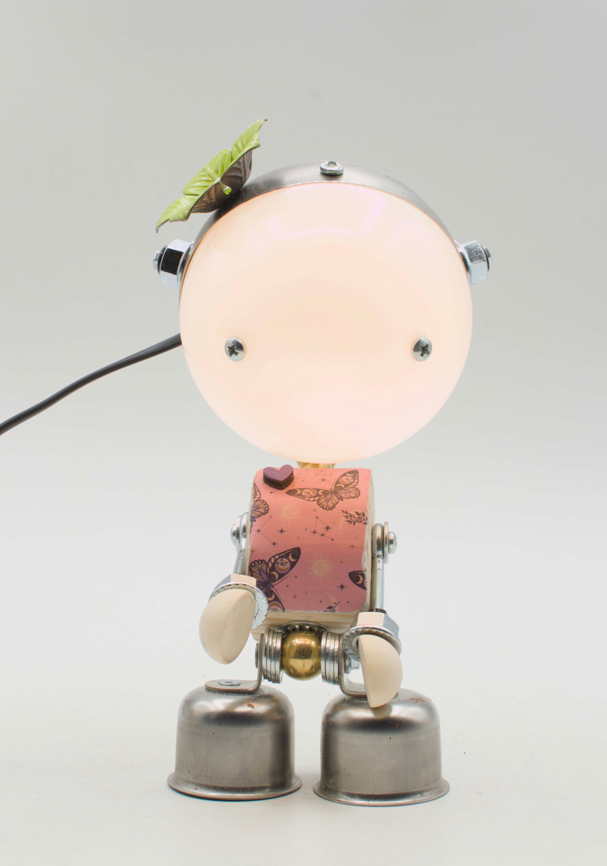 Lampada da tavolo robot stile kodama steampunk con testa circolare luminosa traslucida e accenti metallici argento