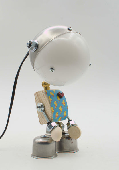 Lampada da tavolo robot kodama in metallo fatta a mano con testa rotonda argento, torso blu con fulmini e piedi a campana