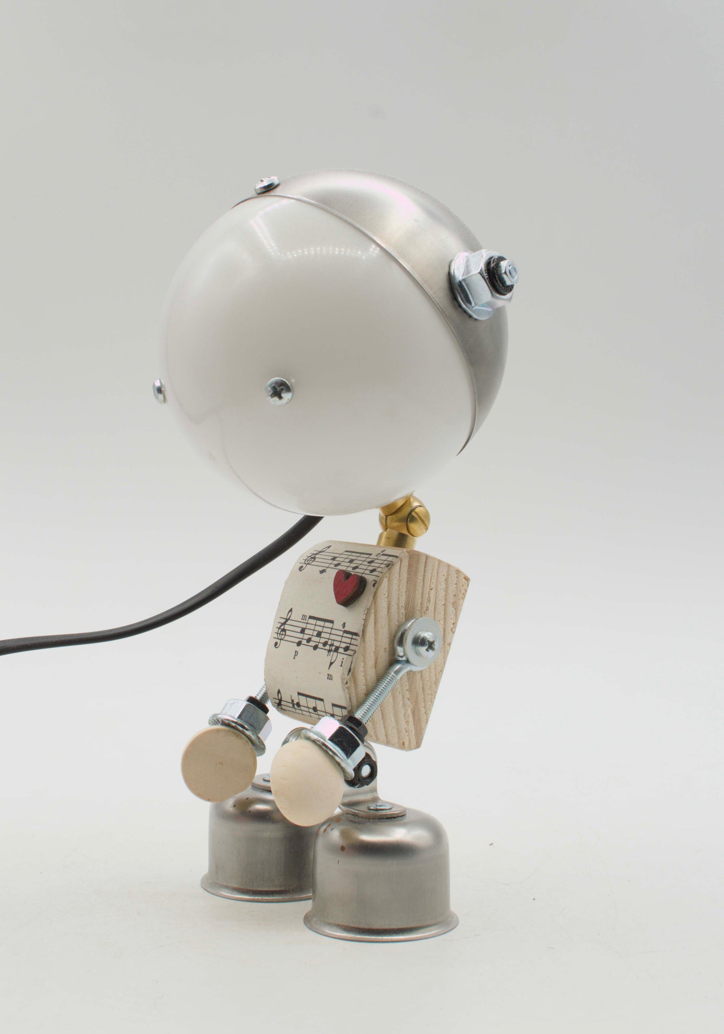Robot lampada da tavolo stile kodama fatta a mano con testa sferica bianca, torso in legno con spartito e cuore rosso