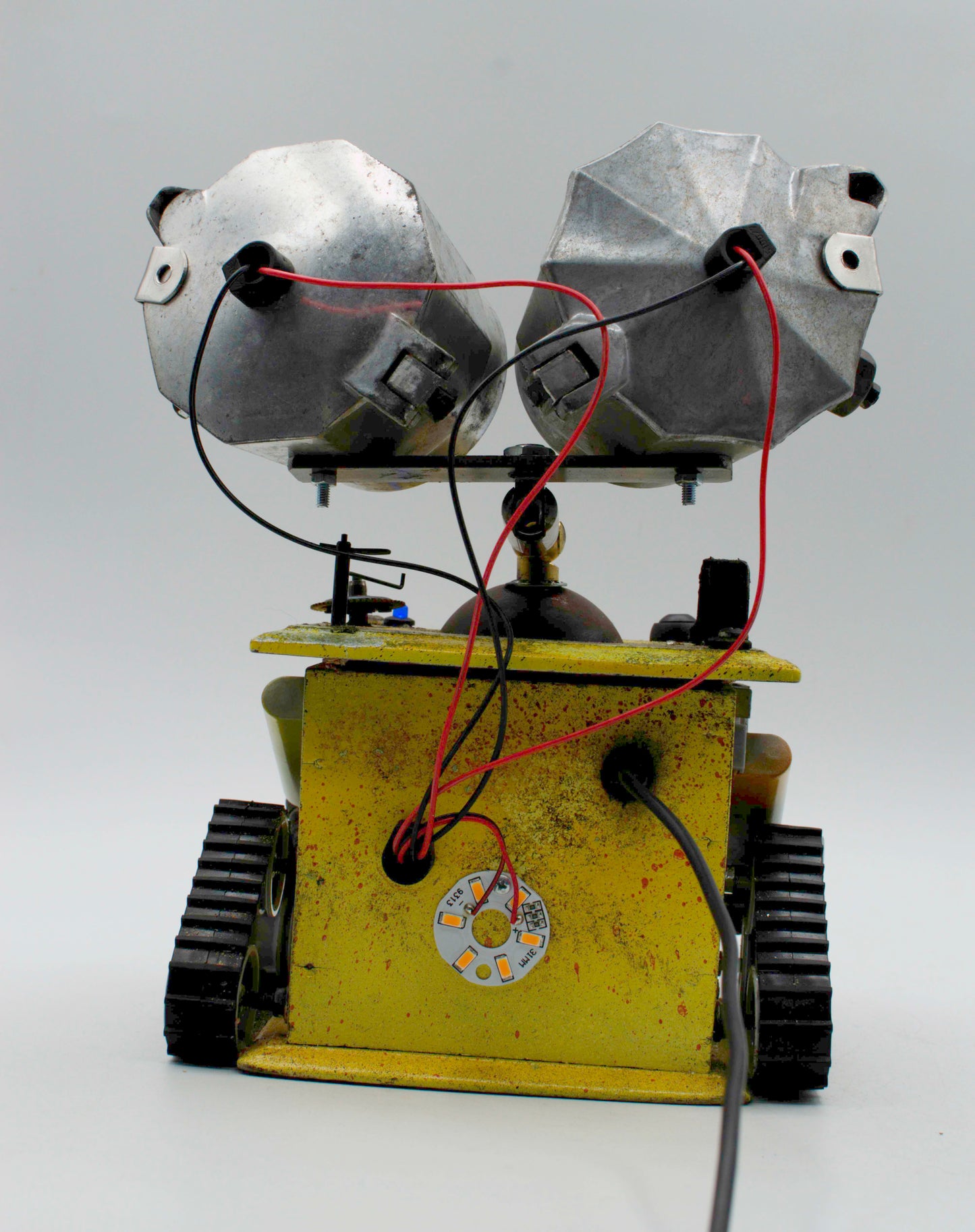 Graziosa lampada creata a mano stile wall e con robot metallico giallo e testine argento facettate su cingoli neri