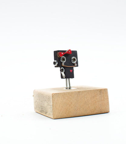Spilla robot in legno nero tagliato a laser con fiocco rosso e occhi a vite metallici fatta a mano