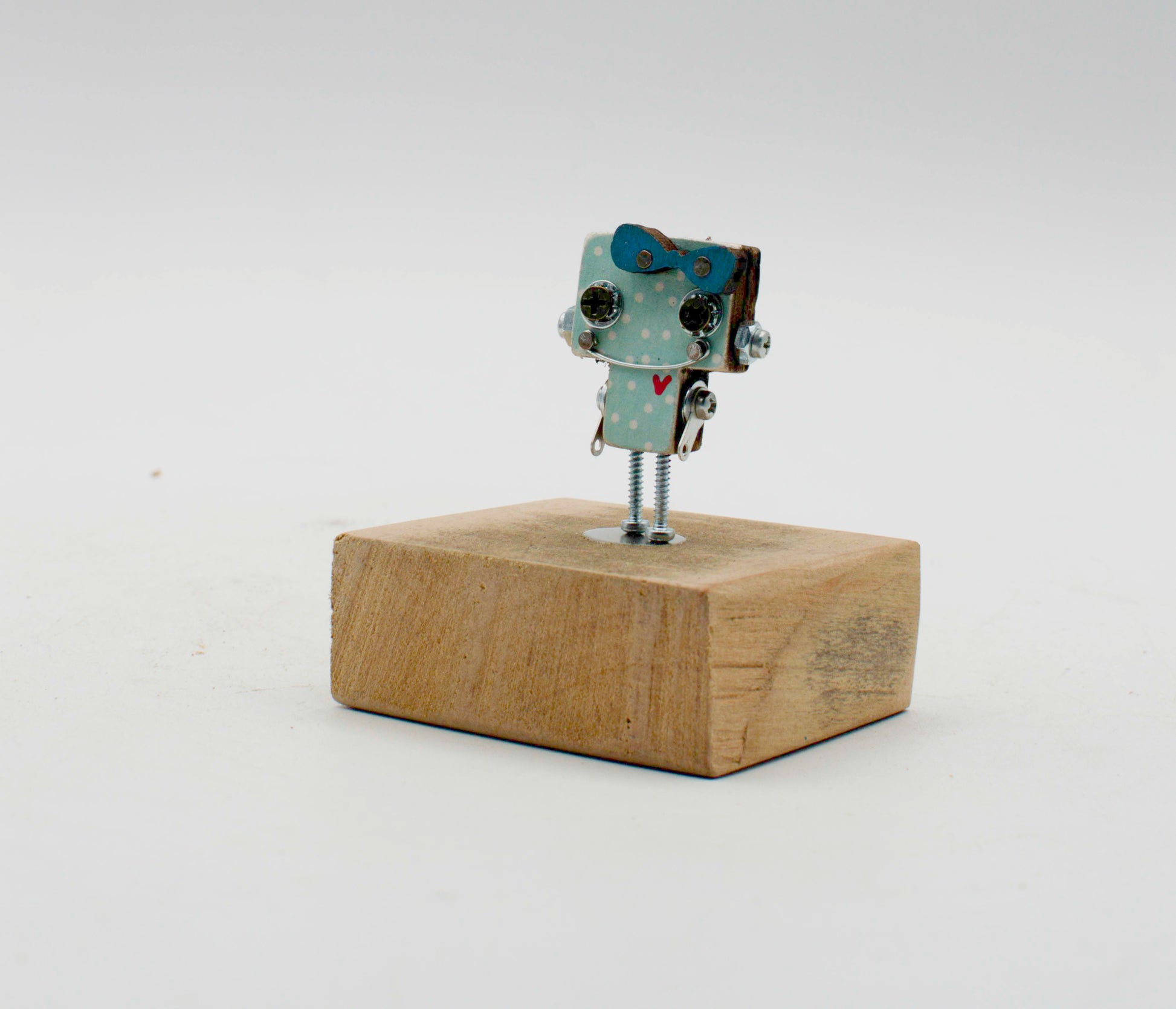 Spilla robot in legno tagliato a laser con corpo azzurro a pois, occhi neri e gambe a vite metalliche, fatta a mano