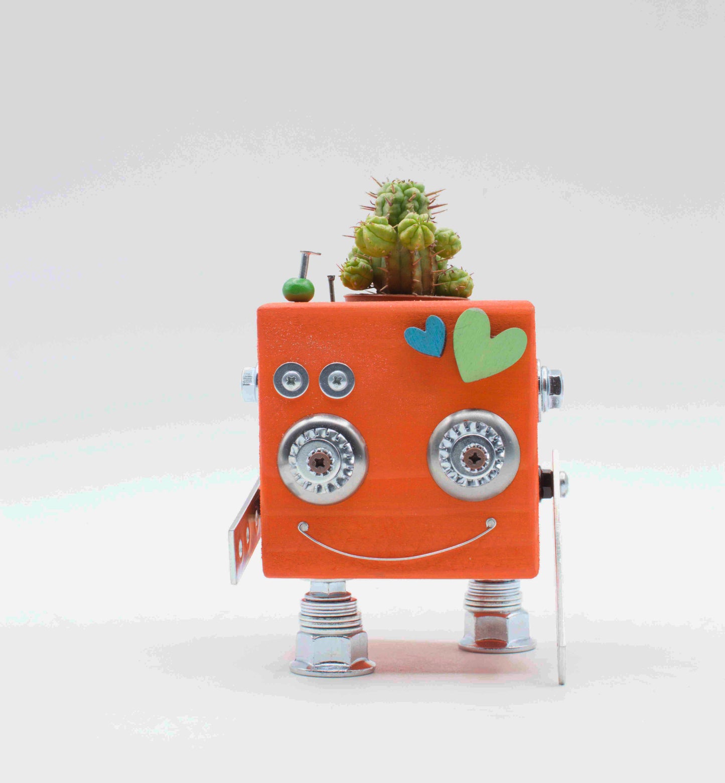 Vaso a forma di robot in legno fatto a mano color pesca con occhi e piedi metallici e piccolo cactus sul lato superiore