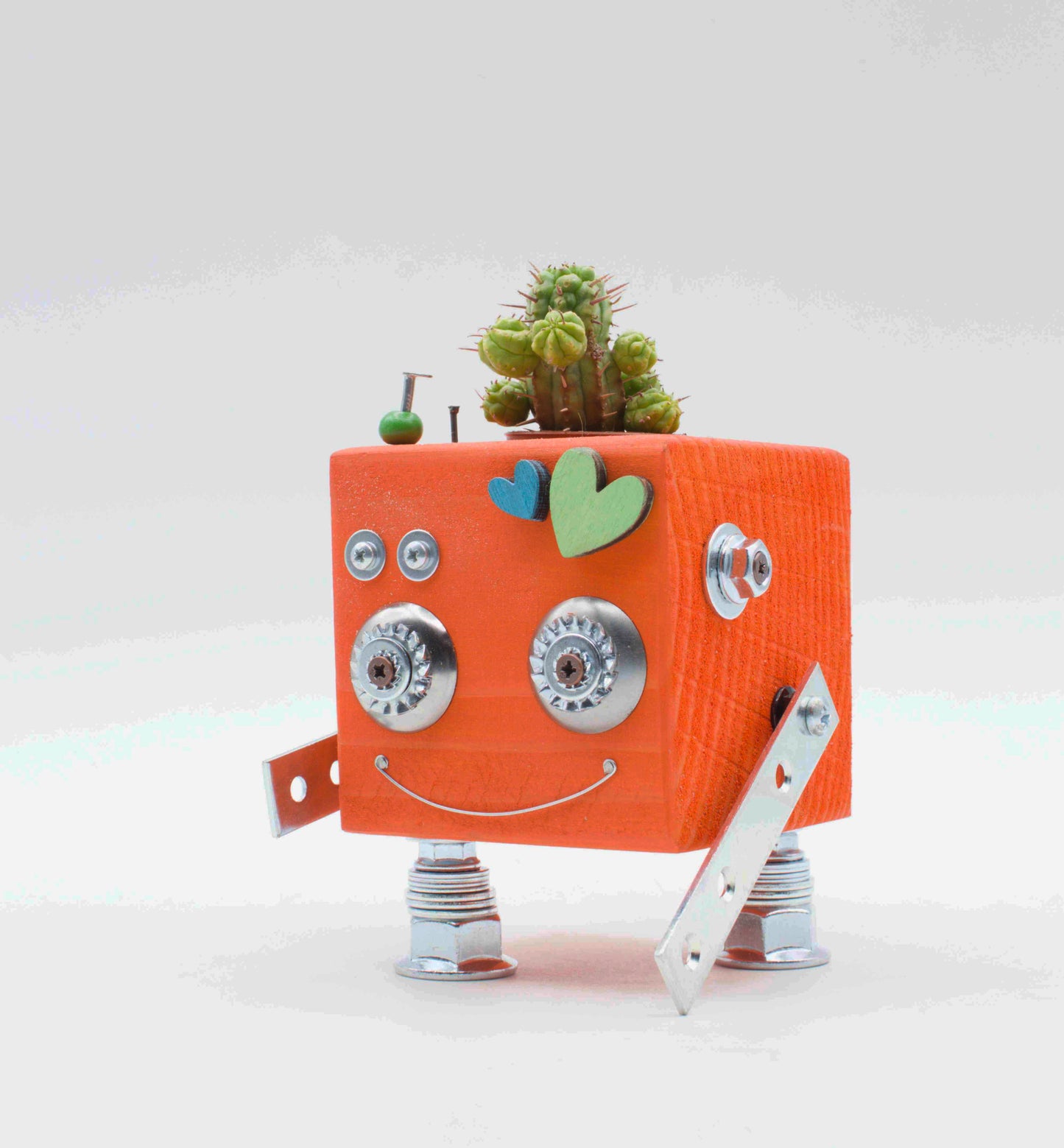 Vasi a forma di robot in legno color pesca con occhi in metallo argento, decorazioni a cuore e piccolo cactus sopra