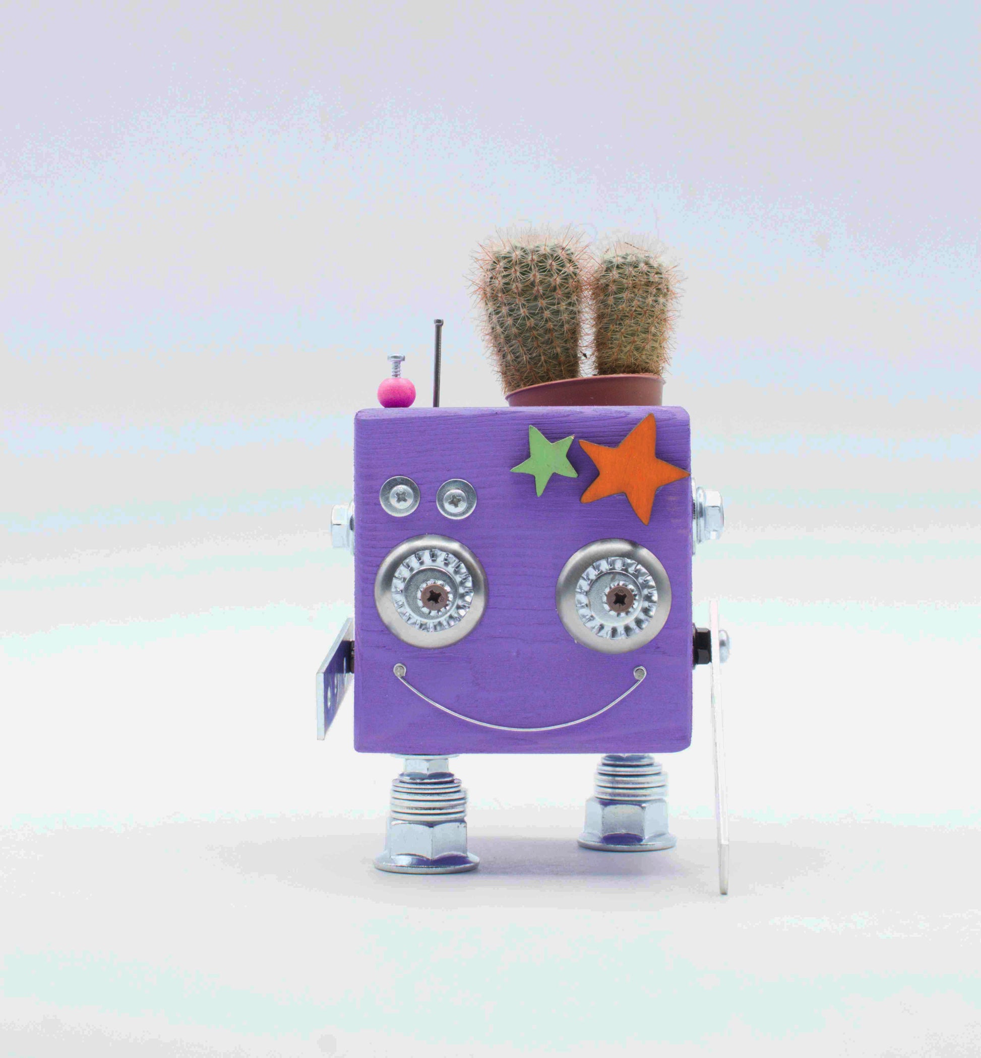 Vaso a forma di robot quadrato viola con occhi argento e sorriso in legno fatto a mano con due piccoli cactus